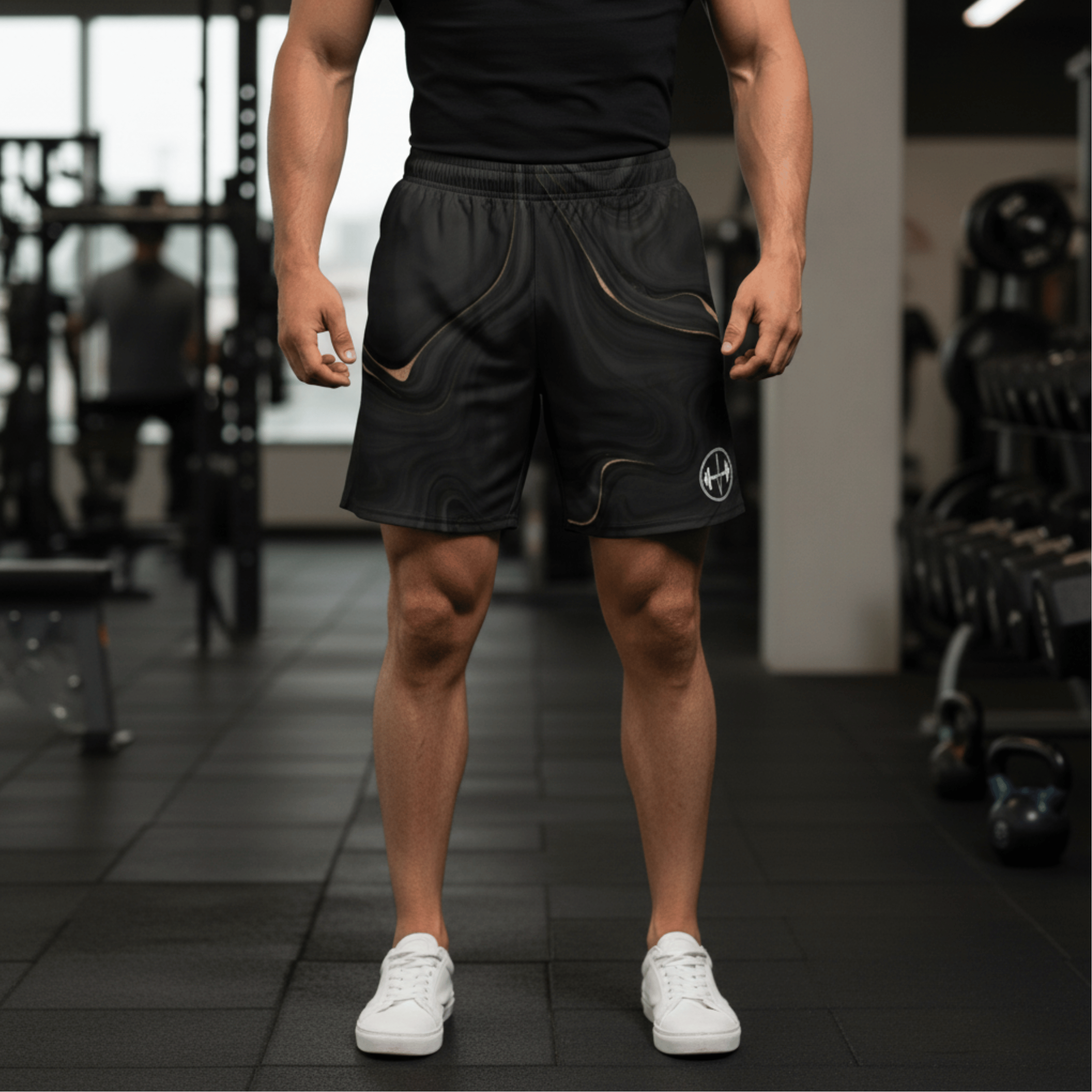 Person wearing black athletic shorts with a logo in a gym setting