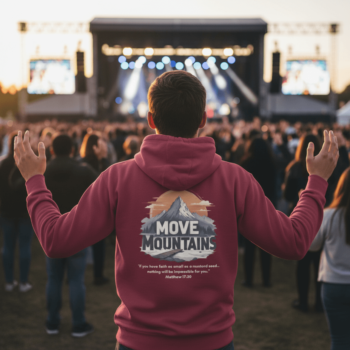Person wearing a red hoodie with 'Move Mountains' design at a concert.