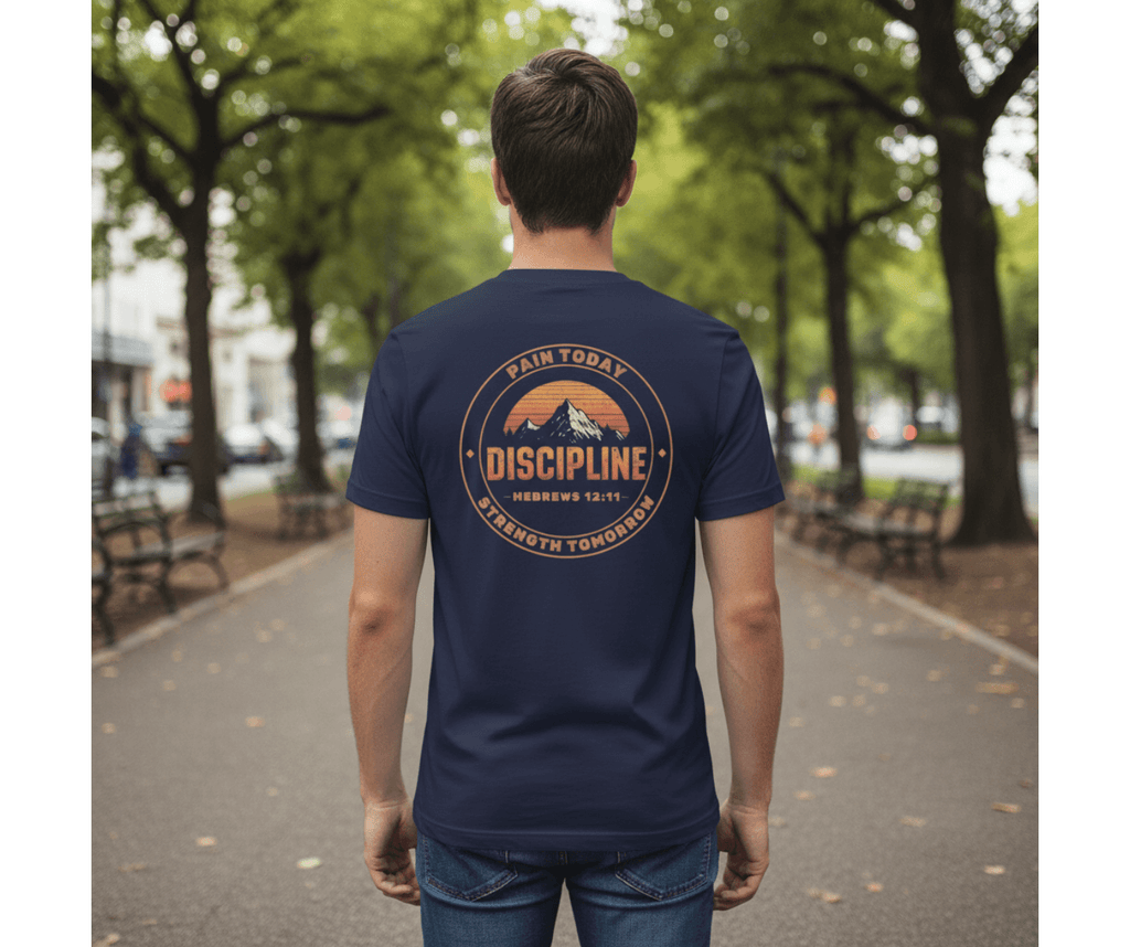 Person wearing a navy blue t-shirt with a motivational quote on the back, standing on a tree-lined street.