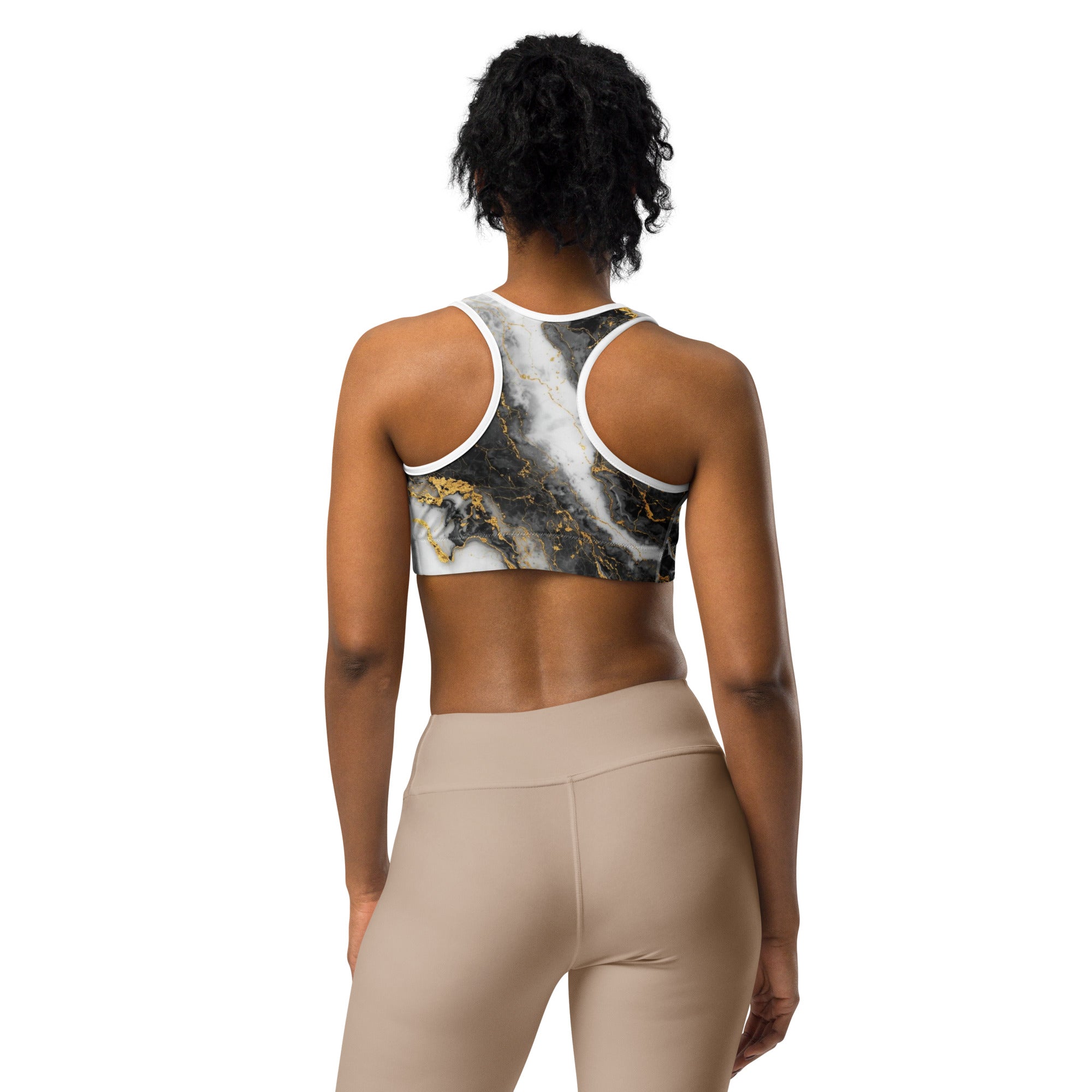 Person wearing a marble-patterned sports bra and beige leggings on a white background