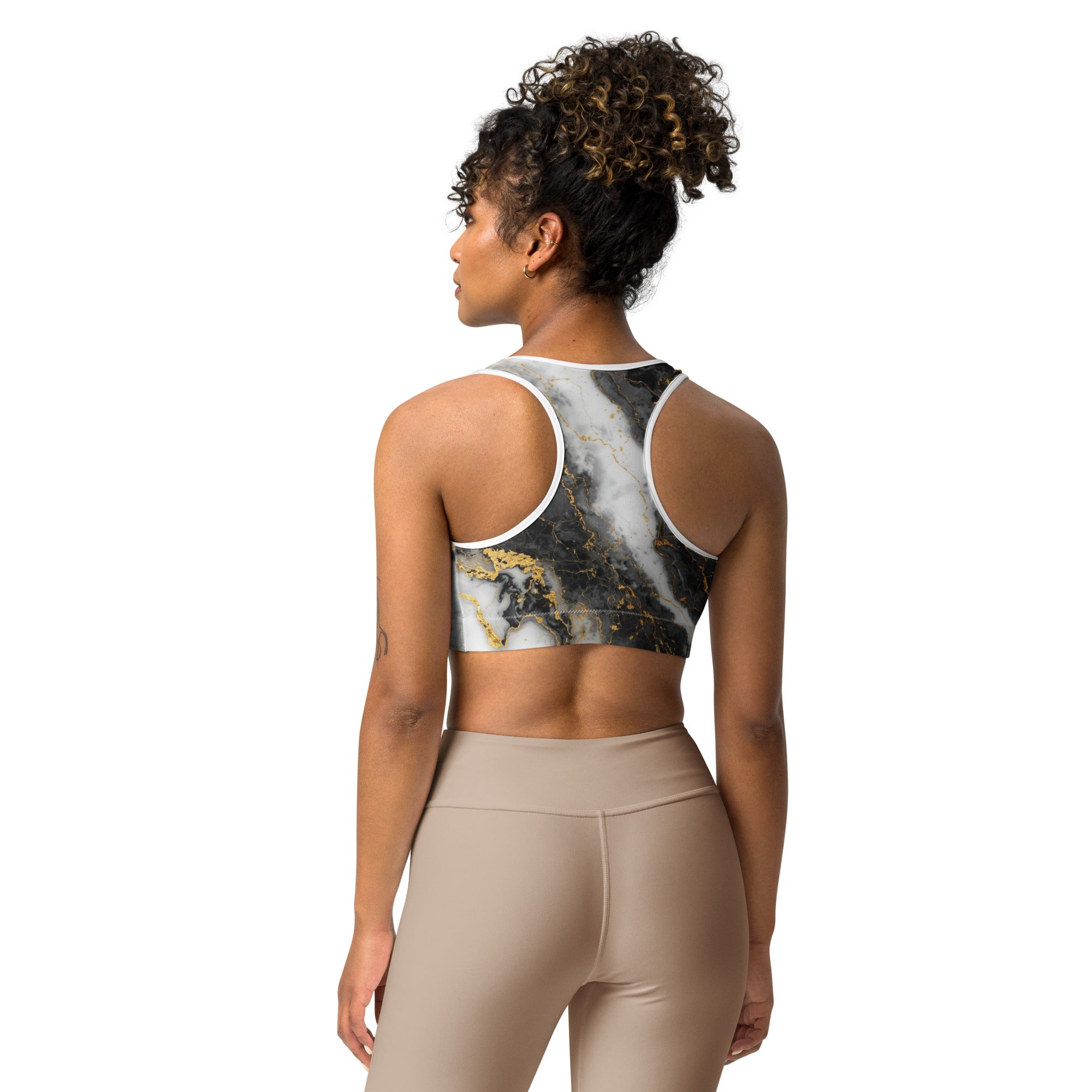 Person wearing a sports bra and leggings with a marble pattern on a white background