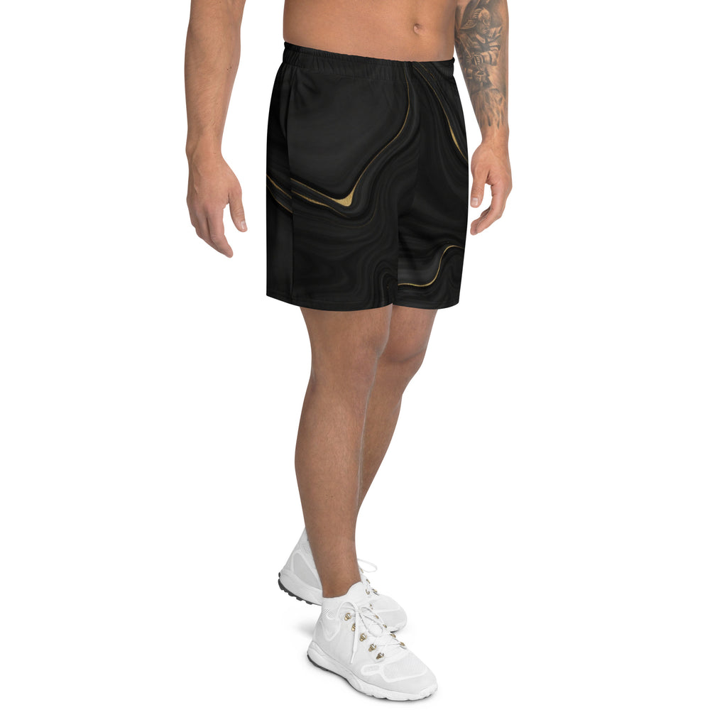 Person wearing black shorts with gold accents on a white background